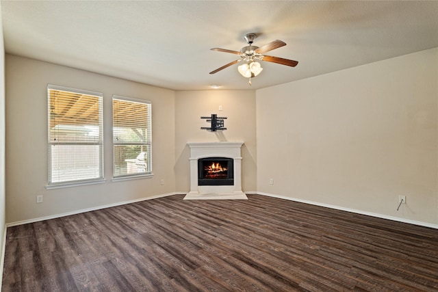 unfurnished living room with dark hardwood / wood-style flooring and ceiling fan