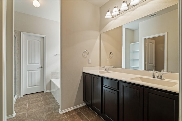 bathroom featuring tile patterned flooring, vanity, and a bathing tub