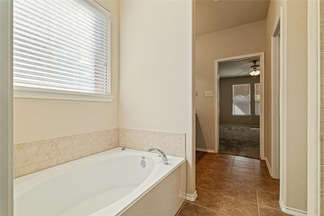 bathroom with tile patterned floors, a bathing tub, and ceiling fan