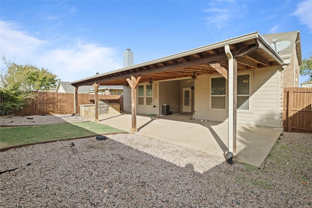 rear view of property with central AC, ceiling fan, a patio, and an outdoor kitchen