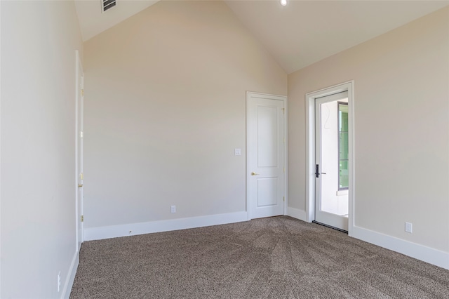 carpeted empty room featuring high vaulted ceiling