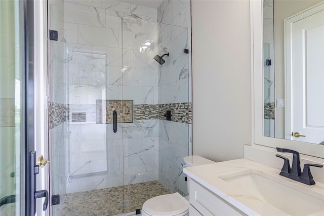 bathroom featuring a shower with door, vanity, and toilet