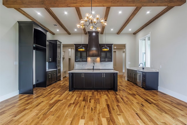 kitchen featuring backsplash, pendant lighting, a notable chandelier, and wood-type flooring