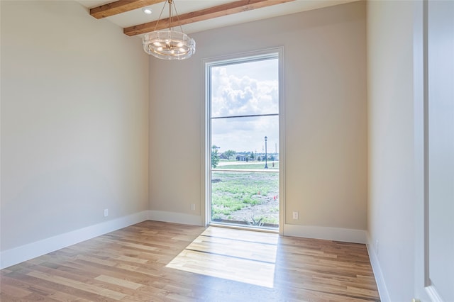 empty room with beamed ceiling, light wood-type flooring, and an inviting chandelier