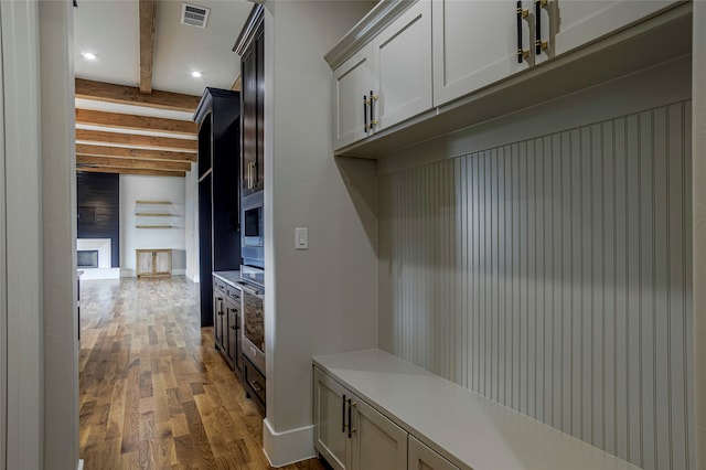 mudroom with light hardwood / wood-style flooring and beamed ceiling