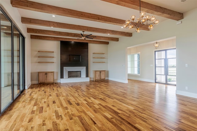 unfurnished living room with a large fireplace, beamed ceiling, ceiling fan with notable chandelier, and light wood-type flooring