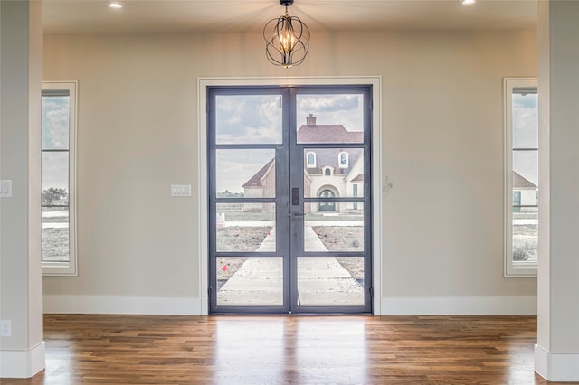 entrance foyer featuring a notable chandelier, a healthy amount of sunlight, and wood-type flooring