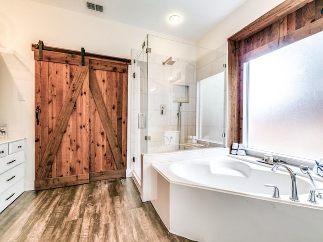 bathroom featuring hardwood / wood-style flooring, vanity, and separate shower and tub