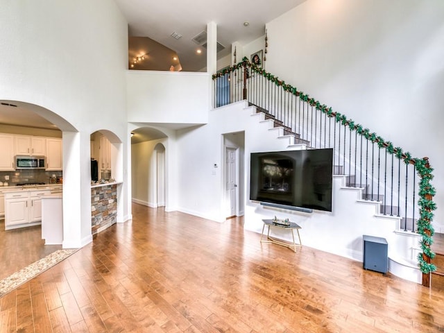 unfurnished living room with hardwood / wood-style floors and a high ceiling