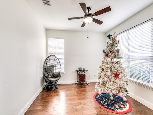 sitting room featuring dark wood-type flooring and ceiling fan