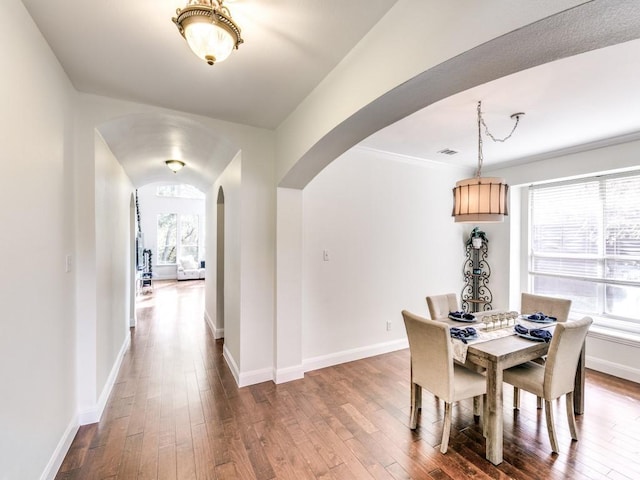 dining area with hardwood / wood-style floors and ornamental molding