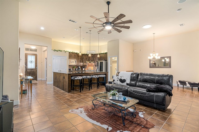 tiled living room featuring ceiling fan with notable chandelier