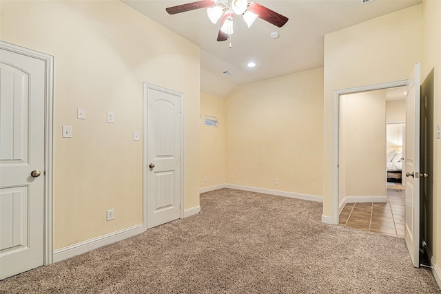 carpeted spare room with ceiling fan and lofted ceiling