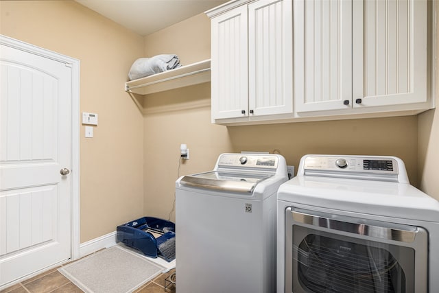 laundry room with tile patterned flooring, washer and dryer, and cabinets