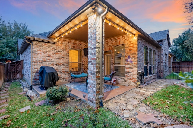 back house at dusk with a patio area