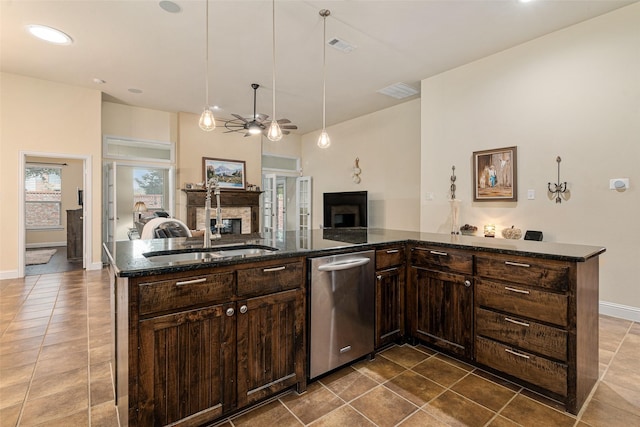 kitchen with sink, dark stone counters, a kitchen island with sink, and dark brown cabinetry