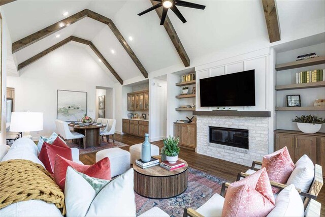 living room featuring ceiling fan, high vaulted ceiling, a fireplace, dark hardwood / wood-style flooring, and beamed ceiling