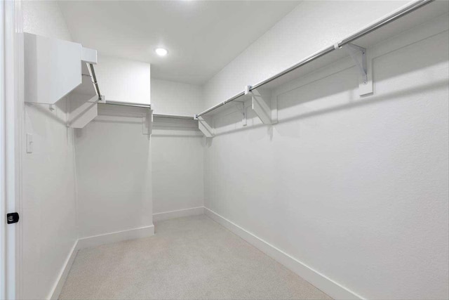 walk in closet with light carpet