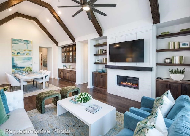 living room with a large fireplace, built in features, dark hardwood / wood-style floors, and beamed ceiling