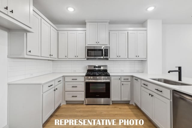 kitchen featuring appliances with stainless steel finishes, sink, and white cabinets