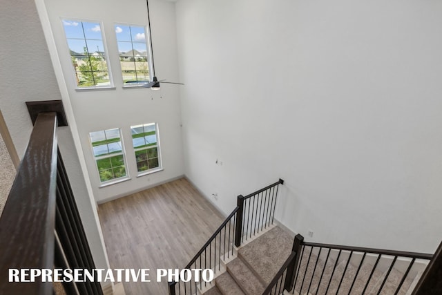 stairway with hardwood / wood-style flooring, ceiling fan, and plenty of natural light