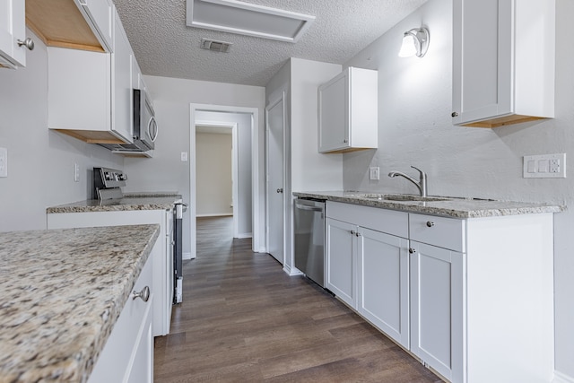 kitchen featuring dark hardwood / wood-style flooring, white cabinetry, sink, and appliances with stainless steel finishes