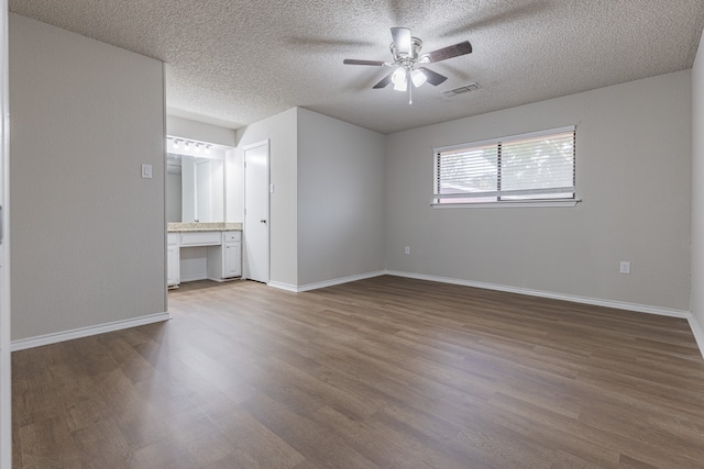 empty room featuring hardwood / wood-style floors, ceiling fan, and a textured ceiling