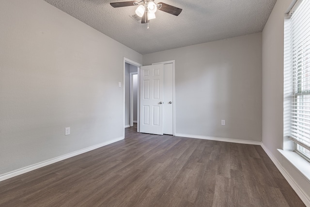 unfurnished room with ceiling fan, dark hardwood / wood-style flooring, and a textured ceiling