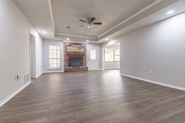 unfurnished living room featuring a raised ceiling, plenty of natural light, and dark hardwood / wood-style floors