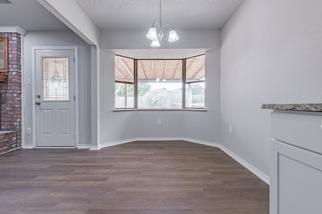 foyer entrance with a notable chandelier, a textured ceiling, and hardwood / wood-style flooring