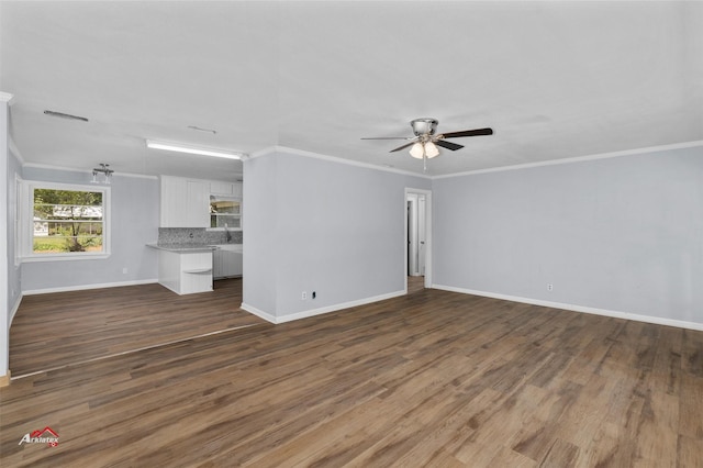 unfurnished living room with dark hardwood / wood-style flooring, crown molding, and ceiling fan