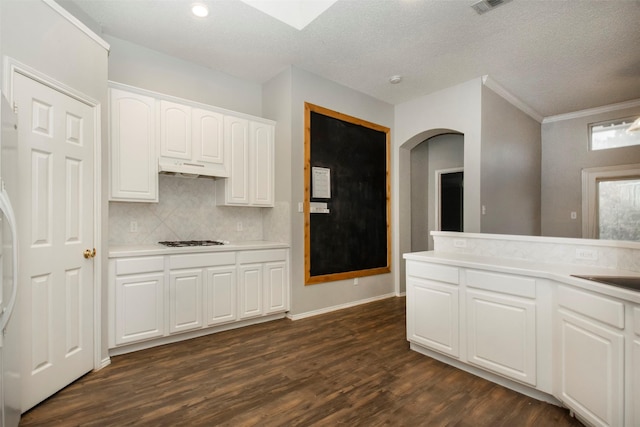 kitchen with white cabinetry, stainless steel gas cooktop, dark hardwood / wood-style flooring, crown molding, and a textured ceiling