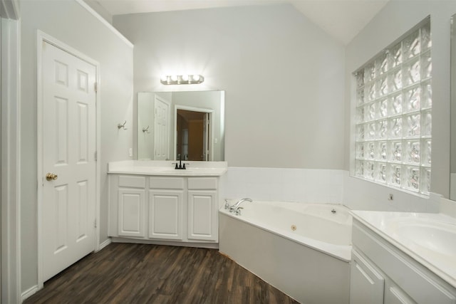 bathroom featuring a bath, vanity, hardwood / wood-style flooring, and vaulted ceiling