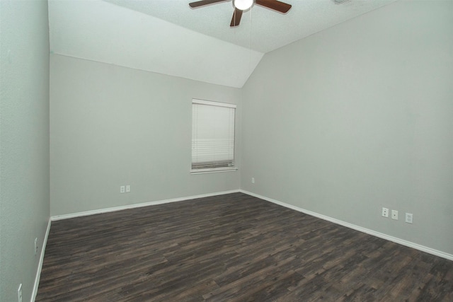 spare room with ceiling fan, dark wood-type flooring, and vaulted ceiling