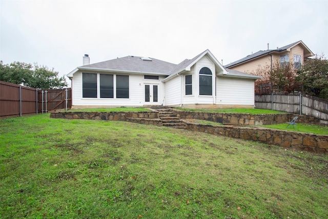 rear view of house featuring a yard and french doors