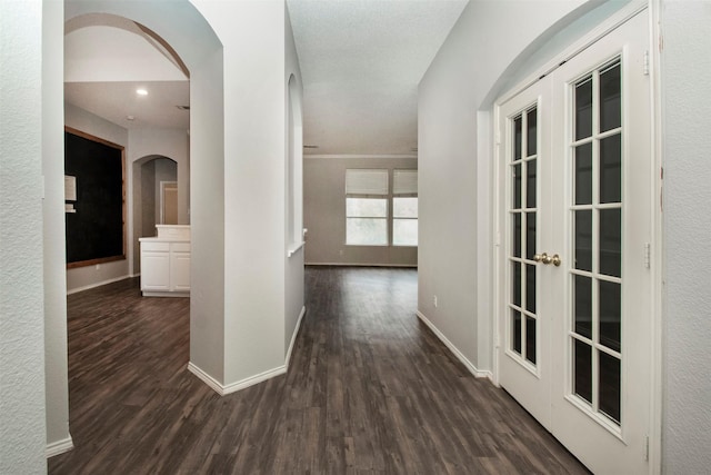 hallway with a textured ceiling, french doors, and dark hardwood / wood-style floors