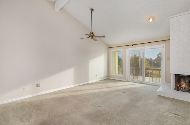 unfurnished living room featuring carpet, vaulted ceiling with beams, ceiling fan, a brick fireplace, and a textured ceiling