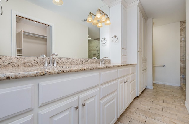 bathroom with a notable chandelier, vanity, and a shower with shower door