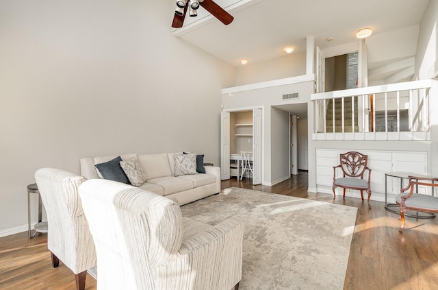 living room with high vaulted ceiling, hardwood / wood-style floors, and ceiling fan