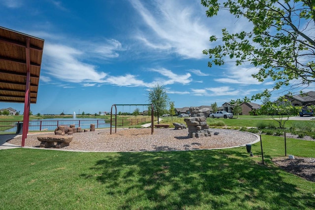 view of playground with a water view and a yard