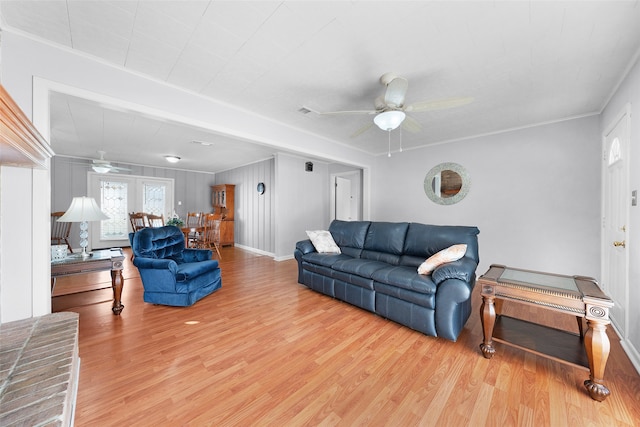 living room featuring hardwood / wood-style flooring, ceiling fan, and ornamental molding