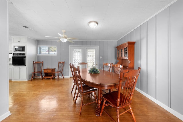 dining area with light wood-type flooring, ceiling fan, and crown molding