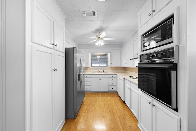 kitchen featuring white cabinetry, sink, stainless steel appliances, light wood-type flooring, and ornamental molding