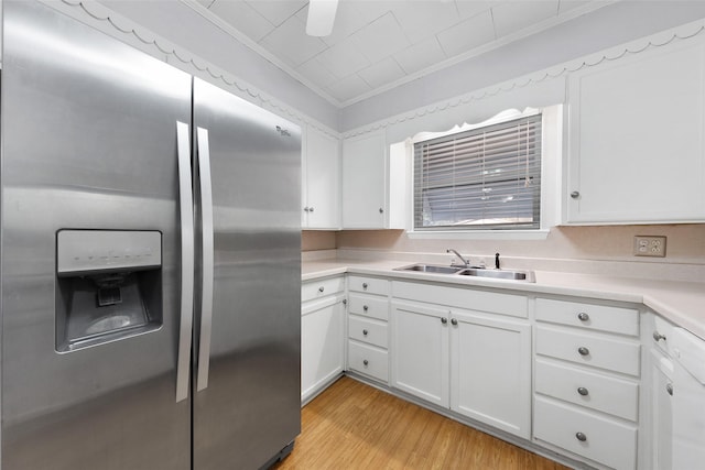 kitchen with stainless steel fridge, light wood-type flooring, white cabinetry, and sink