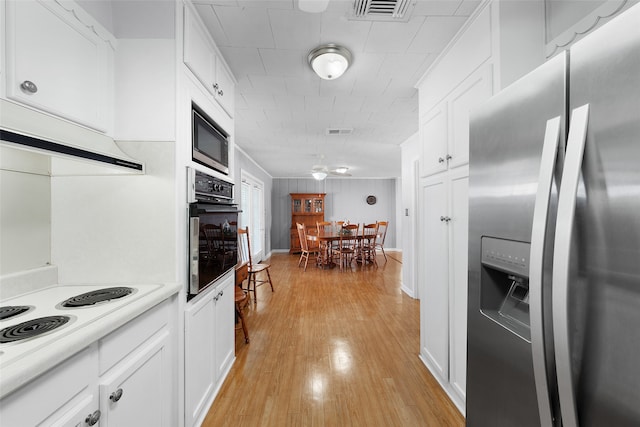 kitchen featuring white cabinets, appliances with stainless steel finishes, and light wood-type flooring