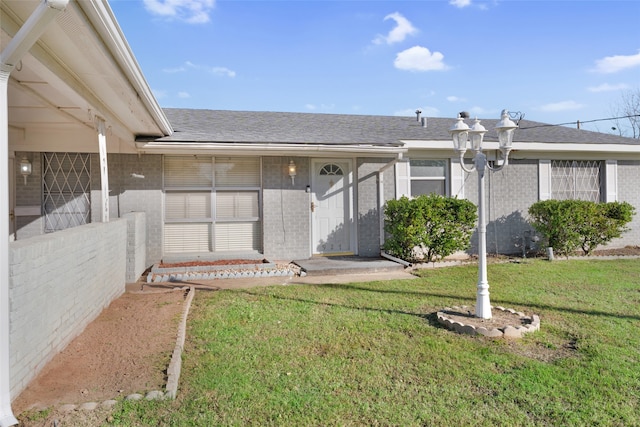 property entrance with a lawn