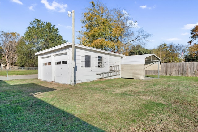 garage with a carport and a yard