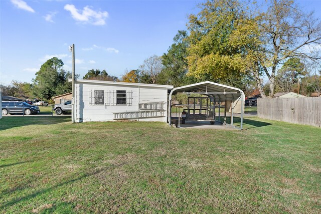 back of house featuring a lawn and a carport