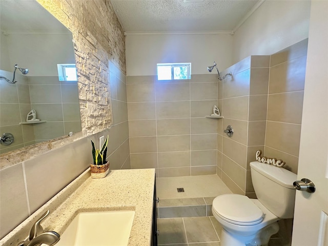 bathroom featuring vanity, crown molding, toilet, a textured ceiling, and tiled shower