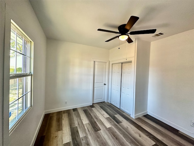 unfurnished bedroom featuring a closet, hardwood / wood-style flooring, and ceiling fan